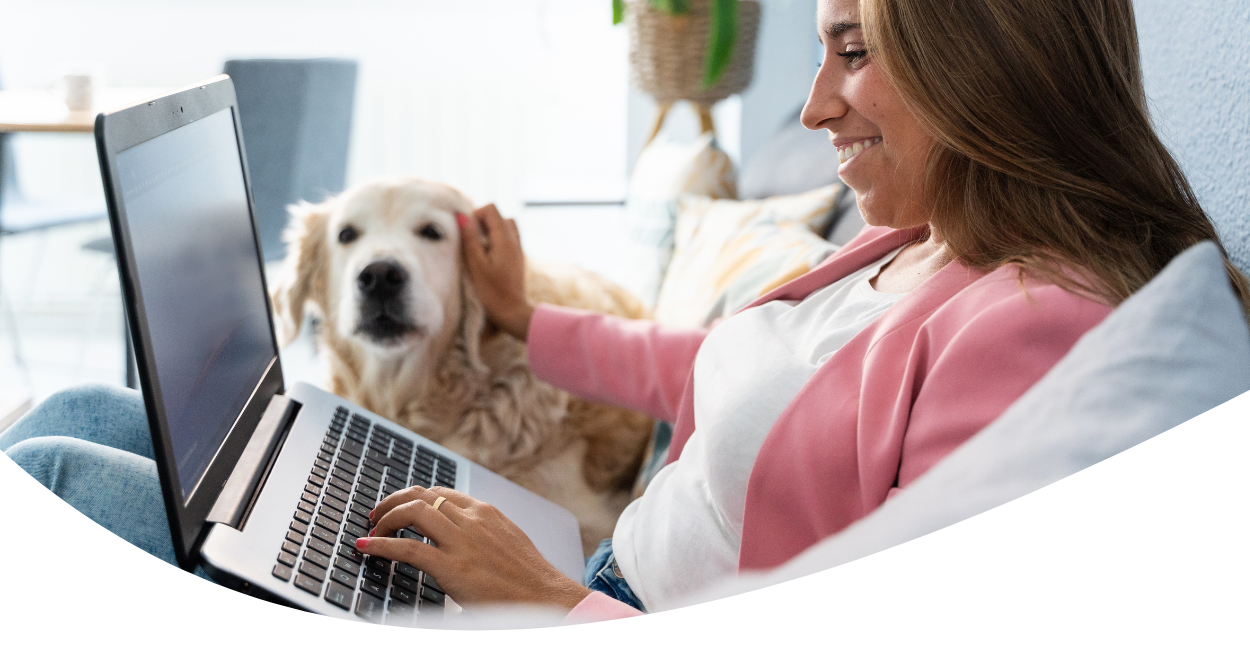 woman petting dog and working on laptop