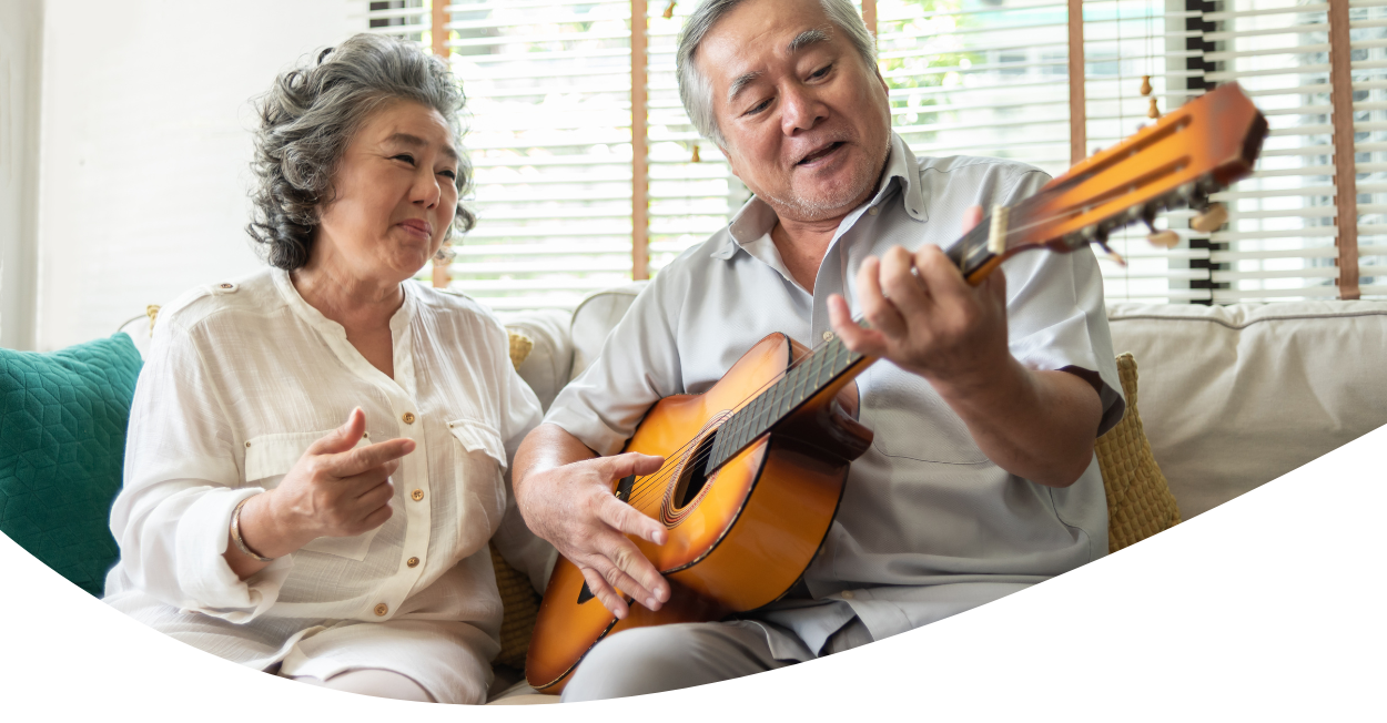 Older Couple Relaxing on Sofa with Guitar
