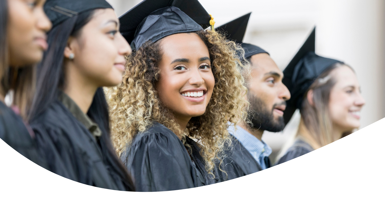 young adults in cap and gowns at graduation