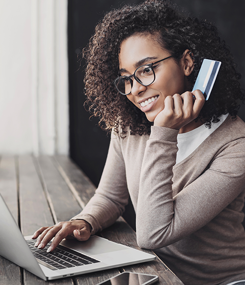 Woman holding credit card and looking at computer