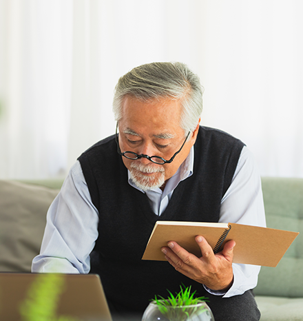 man holding notebook looking at computer