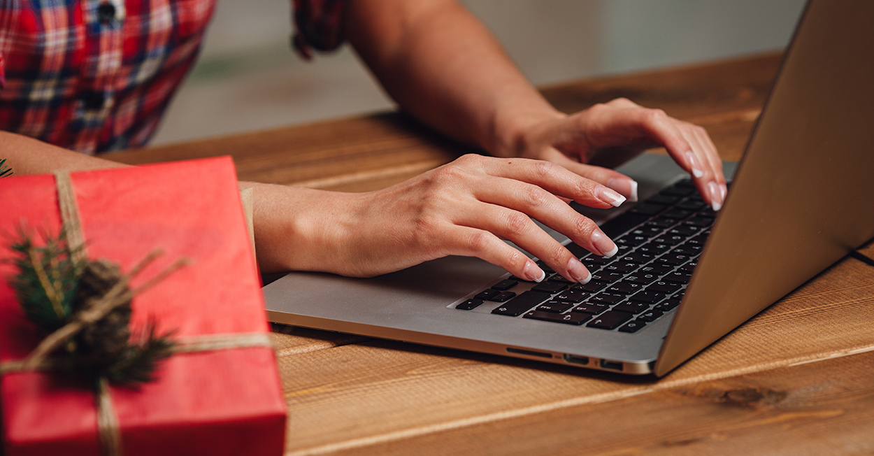 person typing on laptop in holiday setting