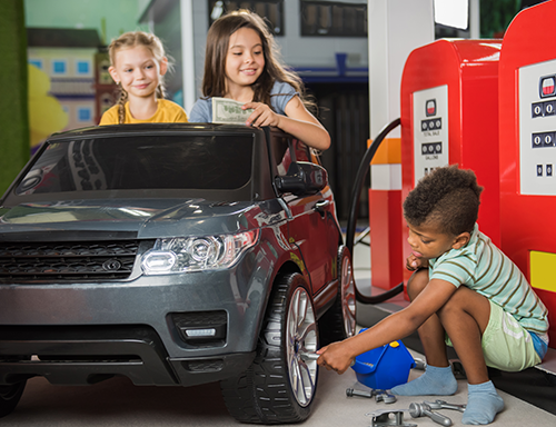 children with toy car pretending to get it repaired