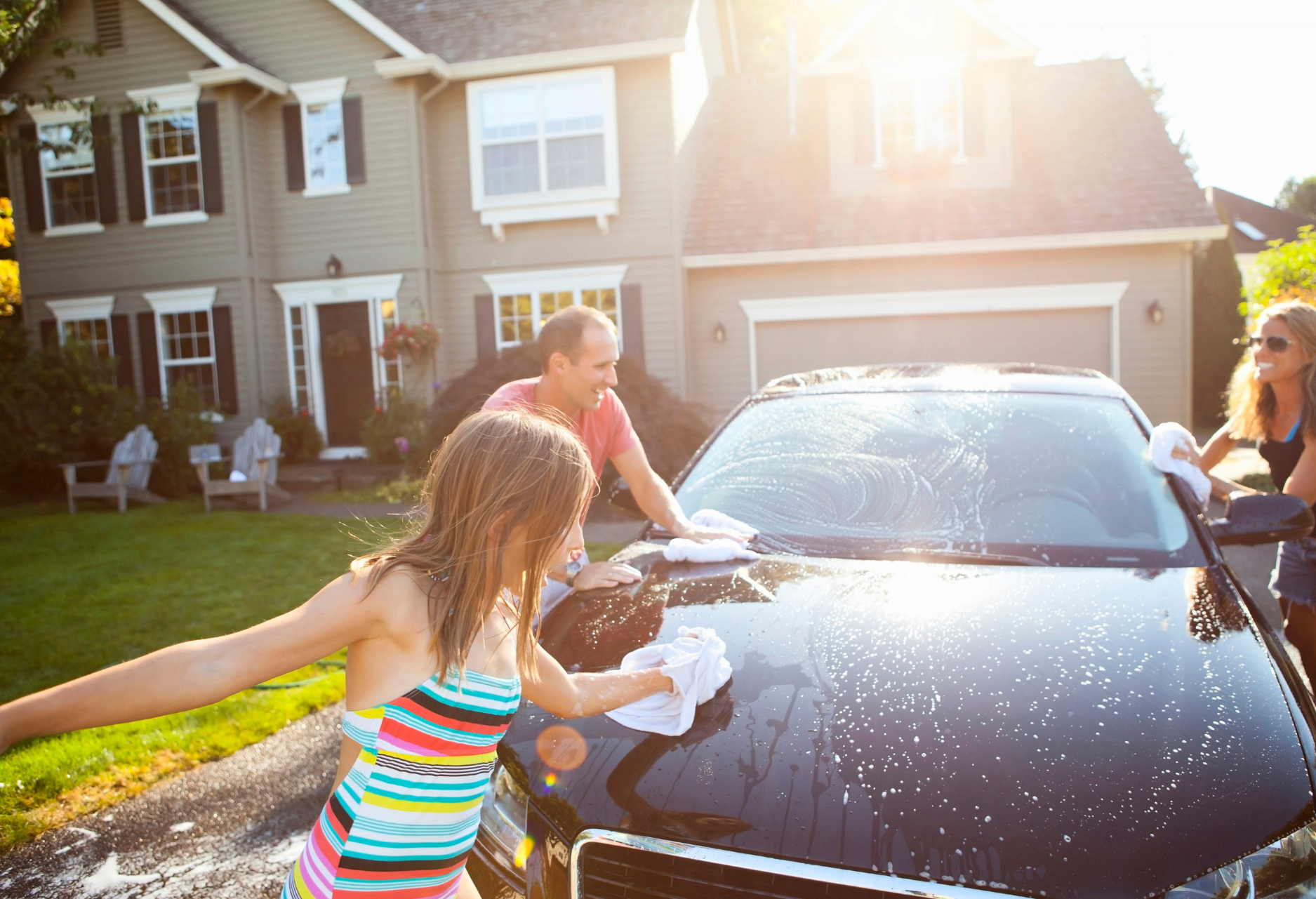 Family washing car image from Travelers