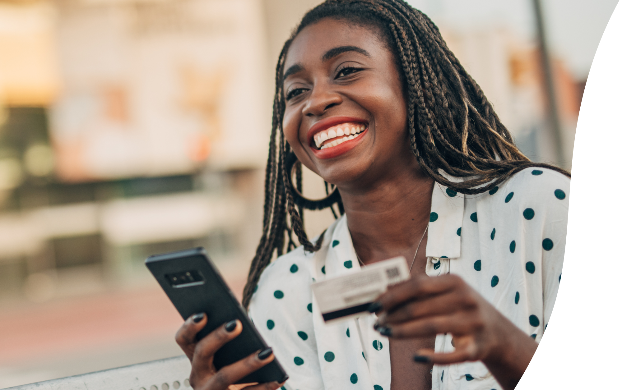 woman smiling and holding phone and debit card