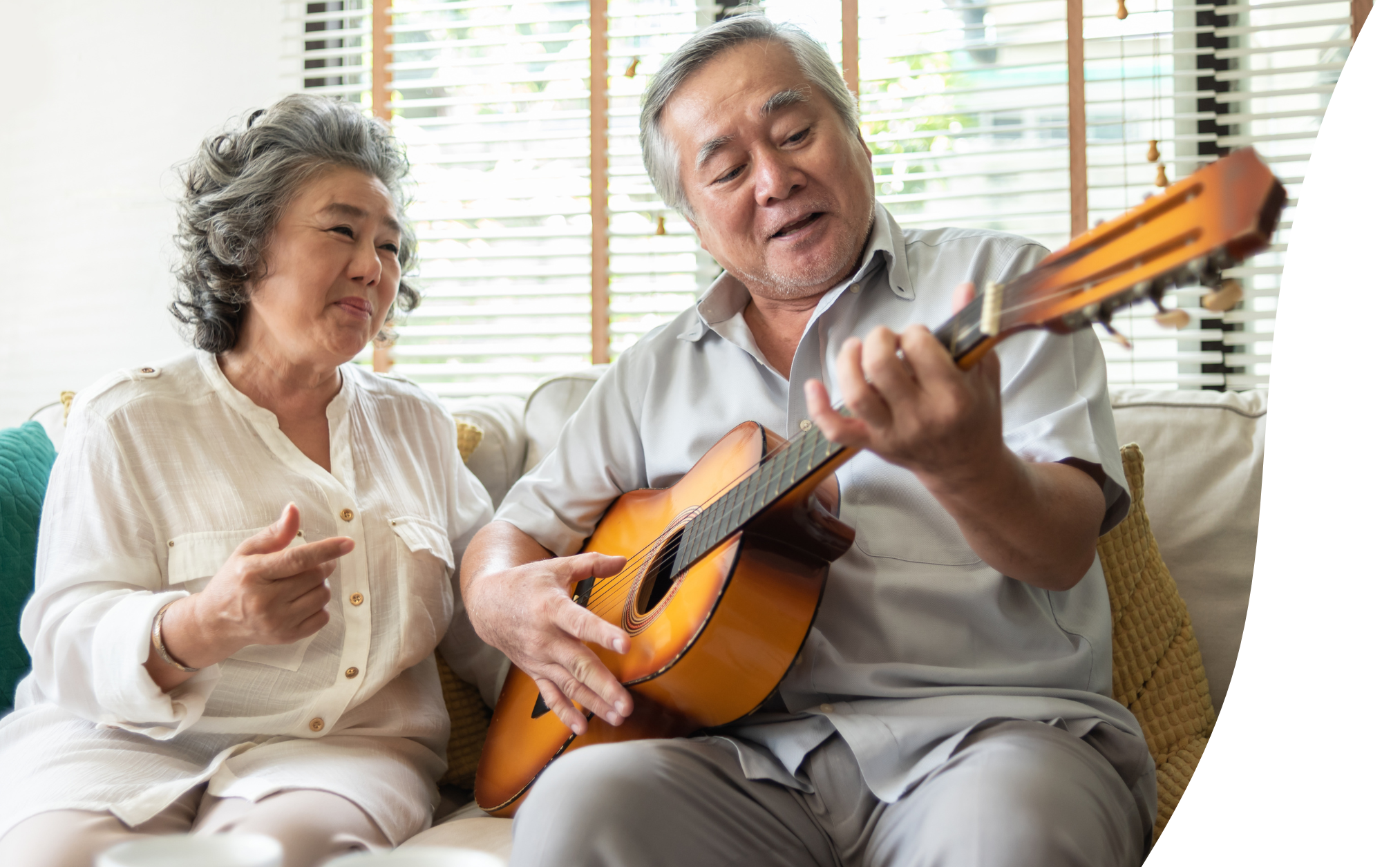 Older couple relaxing on sofa with guitar